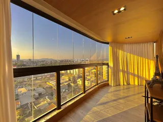 Sala com grande janela oferecendo vista panorâmica da cidade.