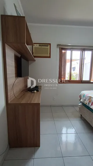 Interior de um cômodo com móveis de madeira e piso cerâmico.