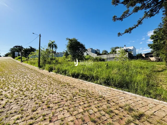 A paisagem exterior da propriedade mostra uma estrada de paralelepípedos e vegetação alta.