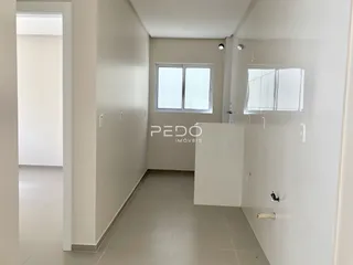 Hall de entrada com paredes brancas e piso claro.