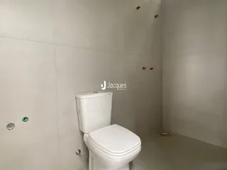 Um banheiro interno com vaso sanitário branco.