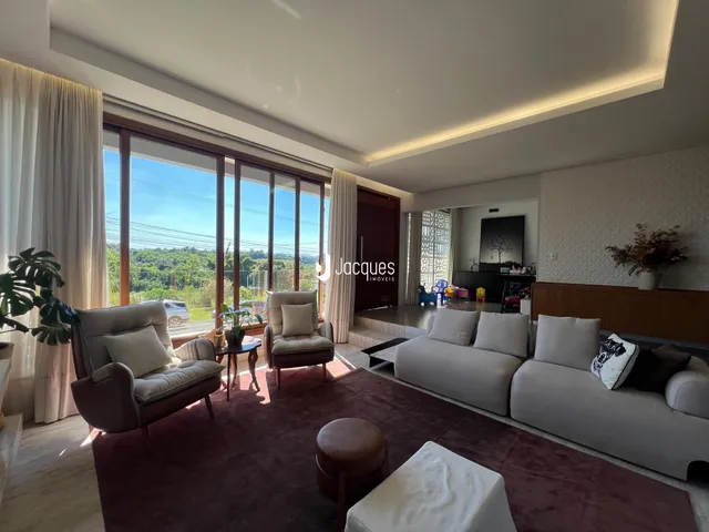 Sala de estar com grandes janelas que oferecem vista para a paisagem externa.