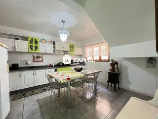 Foto de uma cozinha com armários brancos e mesa de jantar em um imóvel em Lajeado.
