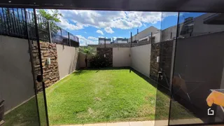 Gramado verde de um quintal com muros de pedra.