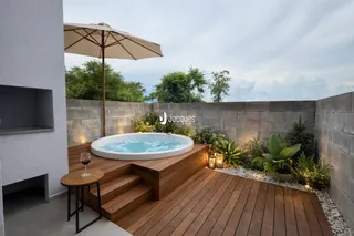 Área externa com jacuzzi e deck de madeira.