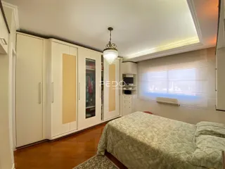 Quarto com armários embutidos e piso de madeira em um imóvel em Lajeado.
