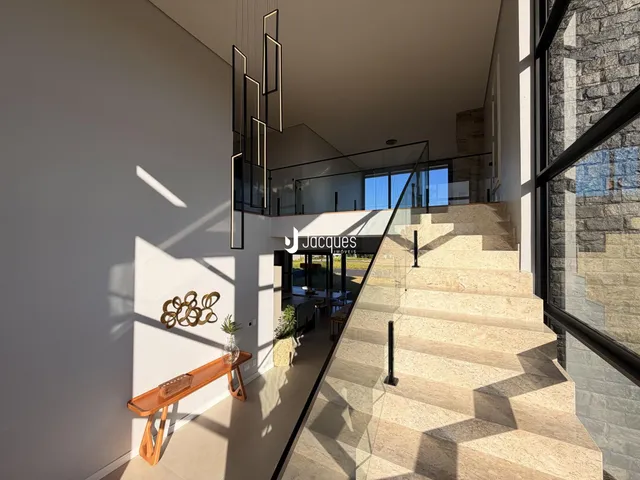 Vista de um hall com escadaria de vidro em um imóvel em Lajeado.