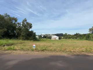 Foto da propriedade em Lajeado, Brasil, mostrando um campo gramado e uma construção ao fundo.