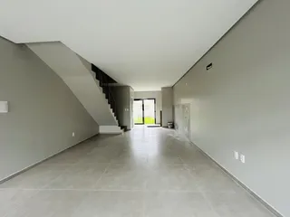 Corredor interno de uma residência com paredes cinzas e piso claro.