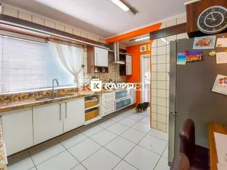 Cozinha com armários brancos e bancada de granito em um apartamento.