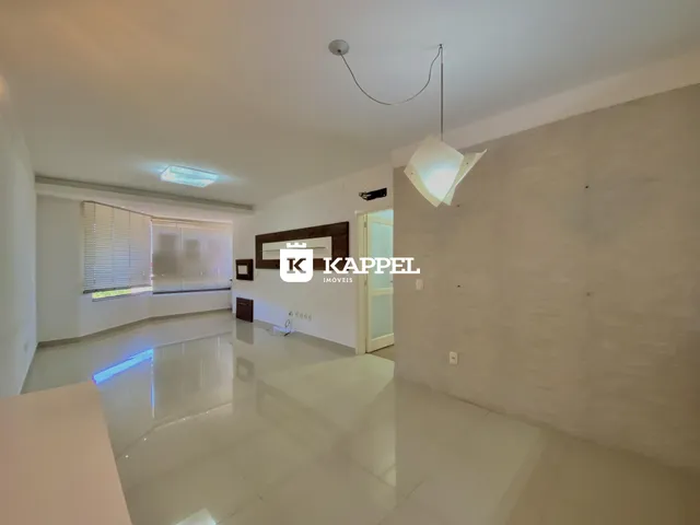 Ambiente amplo com piso claro e iluminação natural em um imóvel.