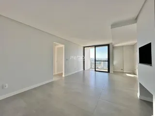 Uma sala de estar ampla com piso de concreto e vista da cidade.