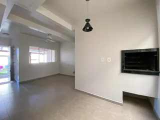 Sala ampla com paredes brancas e piso claro.