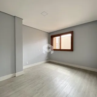 Ambiente interno de uma sala com piso claro e paredes cinzas.