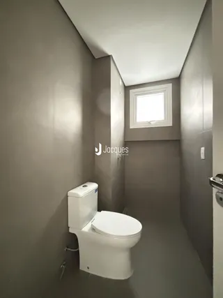Vista de um corredor interno com um vaso sanitário.