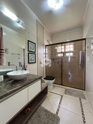 Banheiro com bancada e box de vidro em imóvel no Brasil.