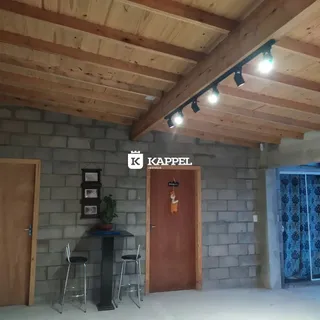 Foto da entrada de uma residência com teto de madeira e porta de madeira.