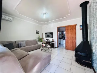 Sala de estar com sofá e lareira em um imóvel no Brasil.