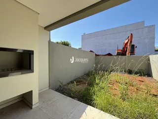Vista externa de uma área com vegetação ao lado de uma parede de construção.