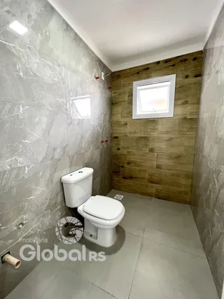 Foto de um banheiro com revestimento de parede em mármore e piso de cerâmica.
