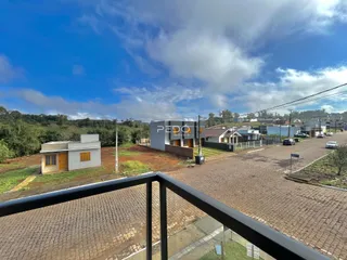 Vista externa de uma propriedade em Lajeado, Brasil, com área pavimentada e vegetação ao fundo.