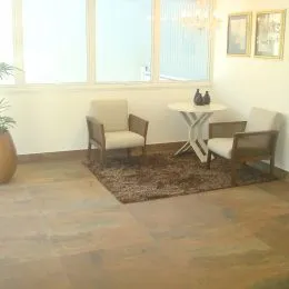 Sala de estar com piso de madeira e grandes janelas.