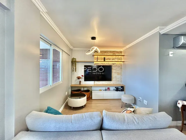 Sala de estar com sofá e janela em um imóvel no Brasil.