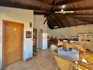 Ambiente interno de uma sala de jantar com teto de madeira e cozinha em Lajeado.