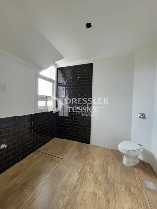 Ambiente interno com paredes de azulejo escuro e piso de madeira clara.