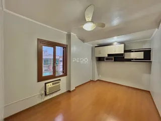 Sala de estar com piso de madeira e janela em um imóvel no Brasil.
