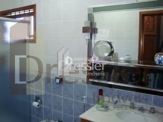Interior com revestimento de azulejos azuis e espelho em um ambiente residencial.