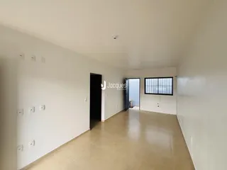 Hall de entrada de uma residência com paredes brancas e piso claro.