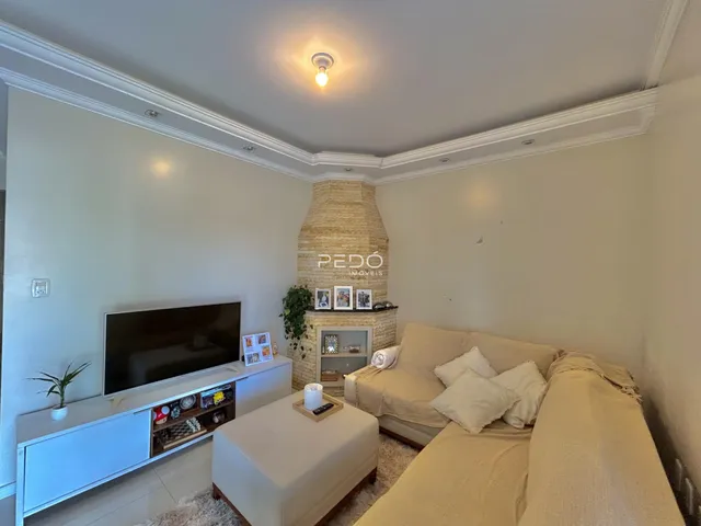 Sala de estar com sofá e lareira em um imóvel no Brasil.