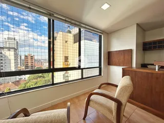 Sala de estar com grande janela de vista para a cidade.