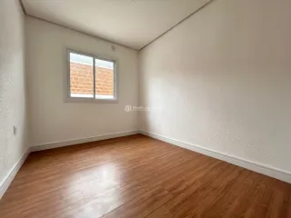 Foto de um cômodo interno com paredes brancas e piso de madeira.