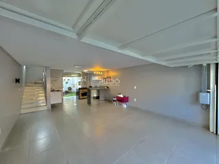 Imagem de uma área interna ampla com piso de cerâmica e cozinha em um imóvel.