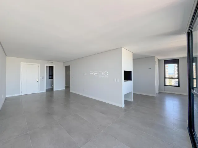 Ambiente interno de uma sala ampla com piso de cerâmica cinza.