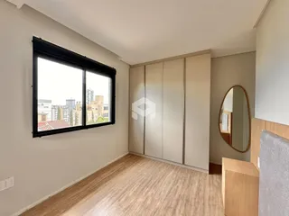 Quarto com janela de grande porte e armários em um ambiente claro.