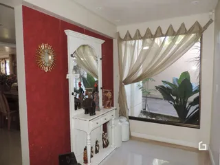Parede vermelha com moldura branca e um espelho decorativo em um ambiente interno.