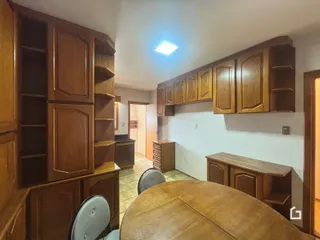 Imagem de uma sala de jantar com armários de madeira no interior de uma residência.