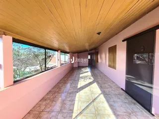 Corredor interno com teto de madeira e piso de cerâmica.