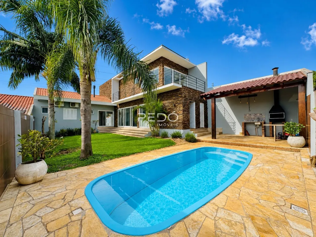 Foto da fachada de uma casa com piscina e jardim em Lajeado.