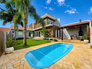 Foto da fachada de uma casa com piscina e jardim em Lajeado.