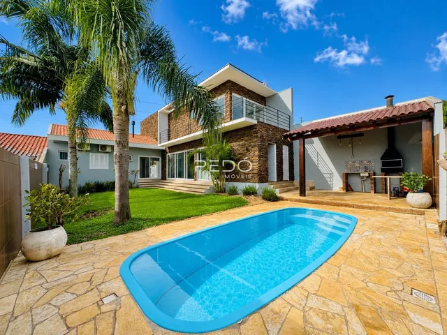 Foto da fachada de uma casa com piscina e jardim em Lajeado.