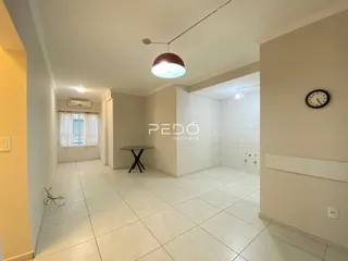 Hall de entrada com piso de cerâmica branca e paredes claras.