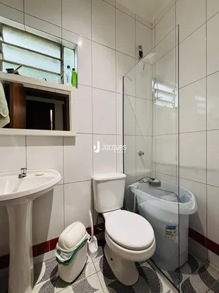 Banheiro com revestimento cerâmico nas paredes e piso.