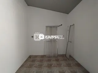 Foto de um cômodo interno com paredes brancas e piso de cerâmica.