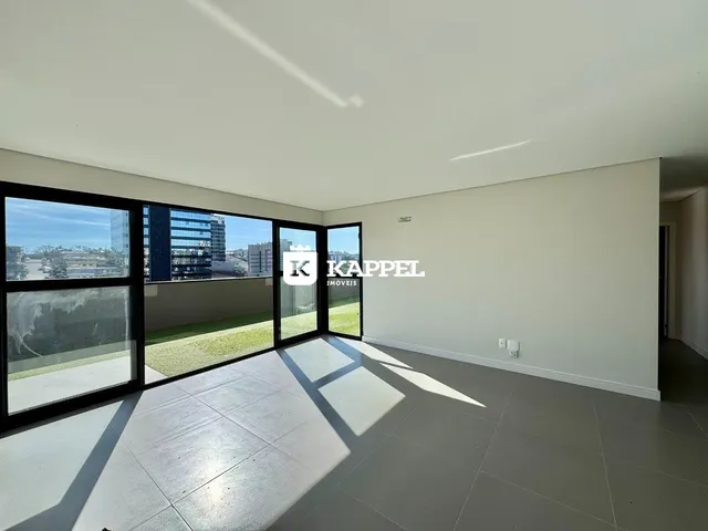 Sala ampla com grandes janelas que oferecem uma vista para o exterior.