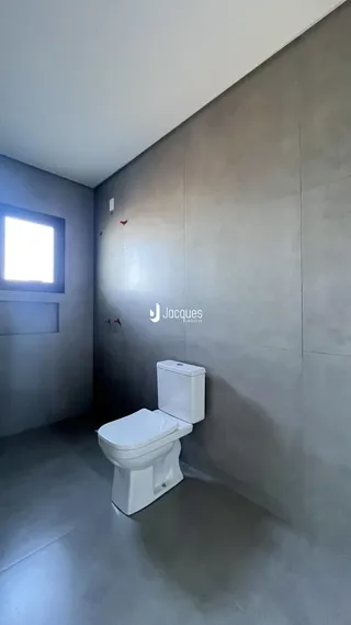 Foto de um banheiro com paredes cinzentas e um vaso sanitário branco.