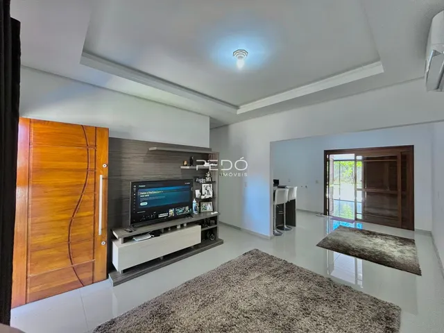 Sala de estar com piso claro e portas de madeira na residência.